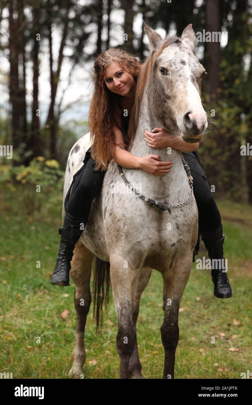 Beautiful girl riding a horse without bridle or saddle in autumn Stock