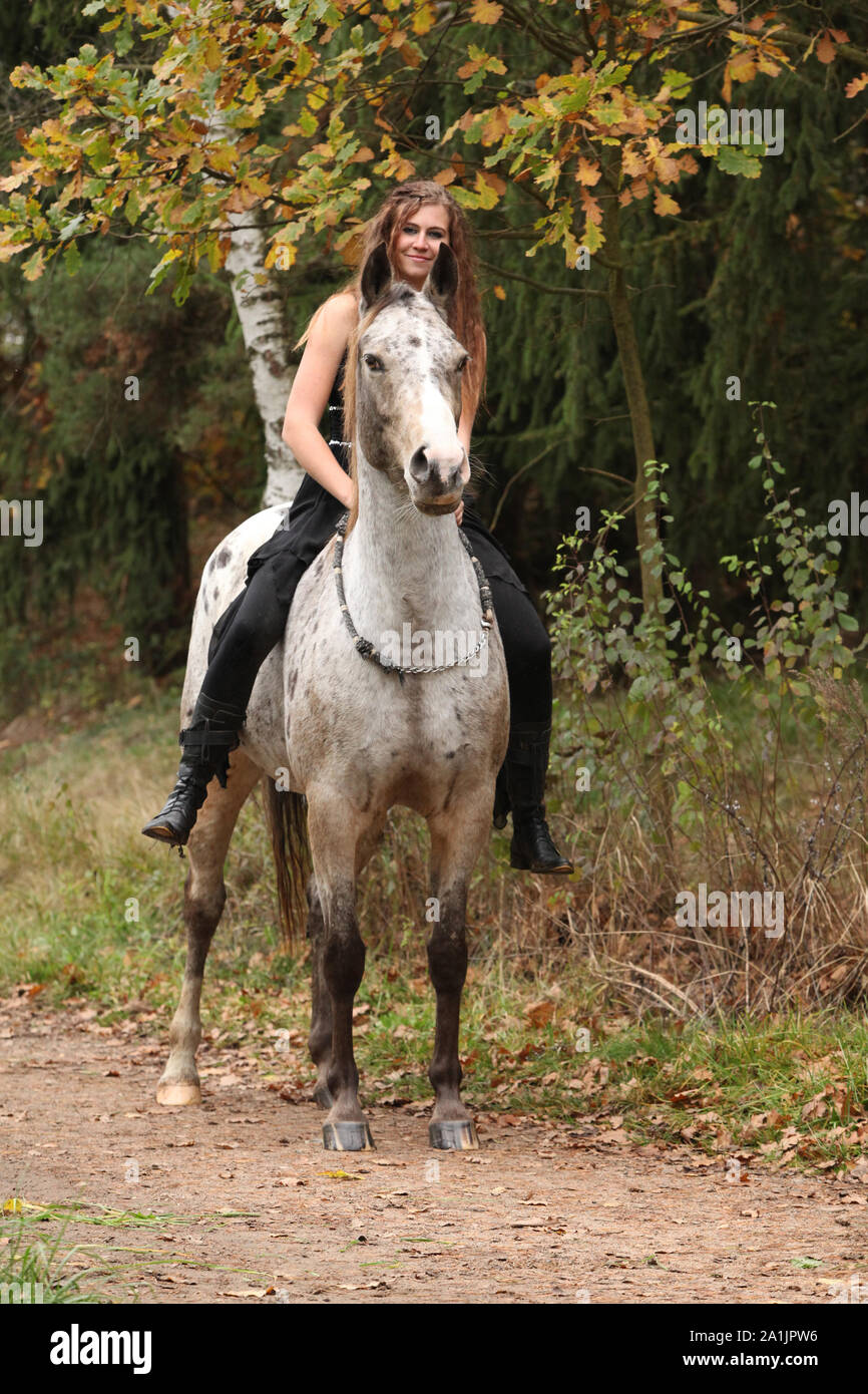 Beautiful girl riding a horse without bridle or saddle in autumn Stock