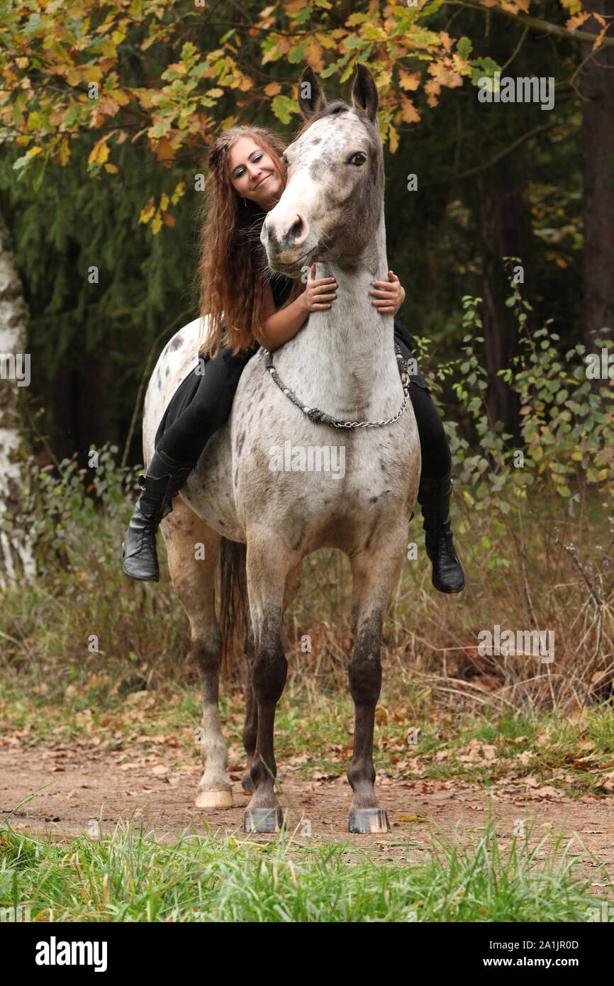 Beautiful girl riding a horse without bridle or saddle in autumn Stock
