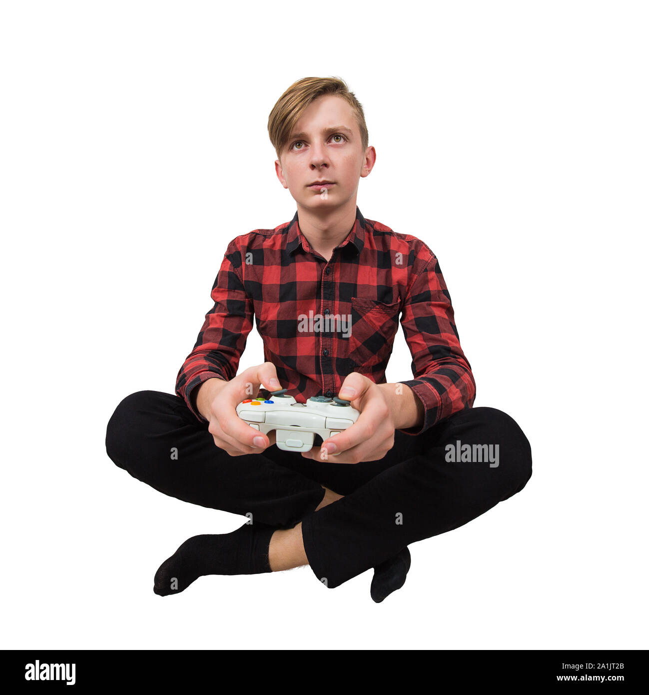 Serious intent teen guy seated on the floor playing video games