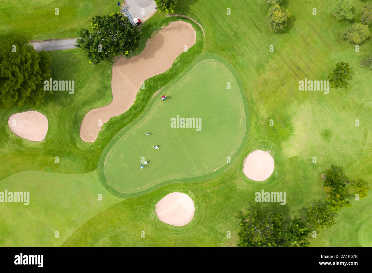 Aerial view of players on a green golf course. Golfer playing on putting green on a summer day. People lifestyle relaxing time in sport field or vacat Stock Photo