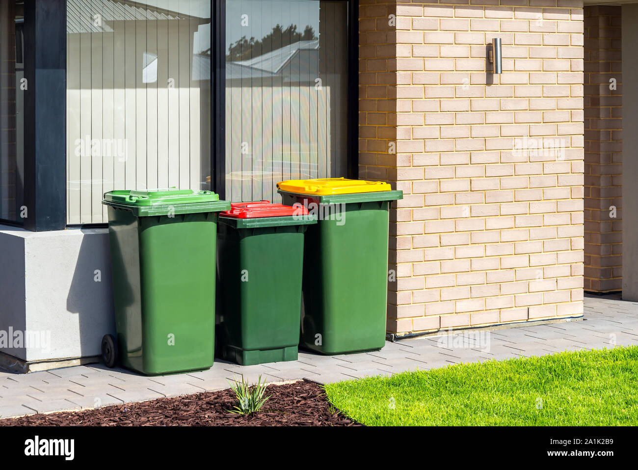 Australian waste wheelie bins with colourful lids for recycling, green and general waste provided by local government Stock Photo