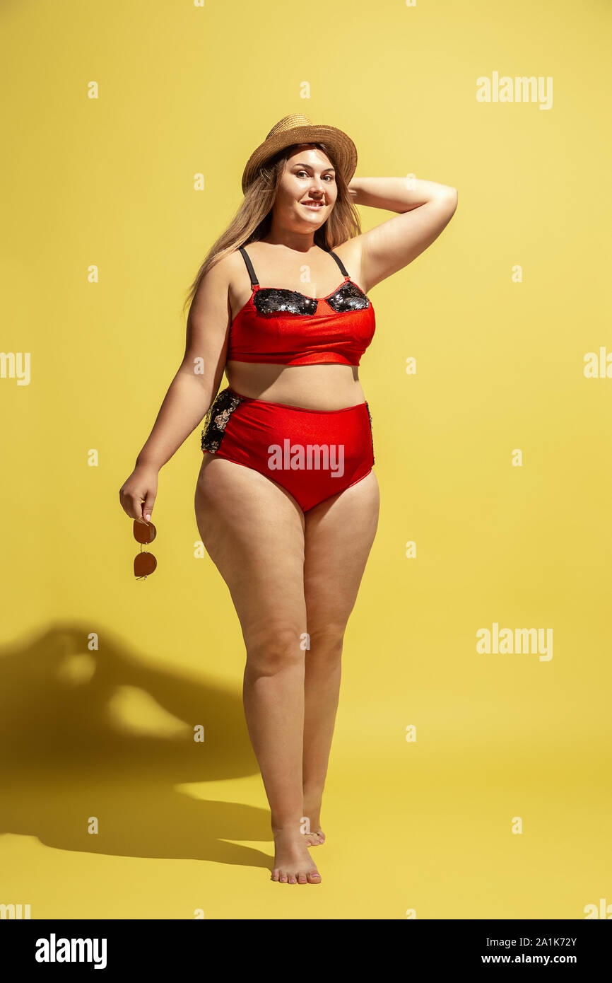 En sætning storhedsvanvid Ansættelse Young caucasian plus size female model's preparing for beach resort on  yellow background. Woman in red swimsuit, hat and sunglasses. Concept of  summertime, party, body positive, equality and chill Stock Photo -