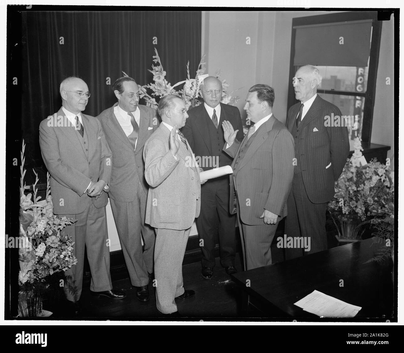 New S.E.C. Commissioner takes oath. Washington, D.C., May 18. Leon Henderson, whose nomination as a member of the Securities and Exchange Commission was recently approved by the Senate, was sworn in and assumed the post today. Left to right: Commissioner Edward C. Eicher, Commissioner Jerome Frank, Francis P. Brassor, Secretary of the Commission who administered the oath, Commissioner George C. Mathews, Leon Henderson, and Commissioner Robert E. Healy Stock Photo