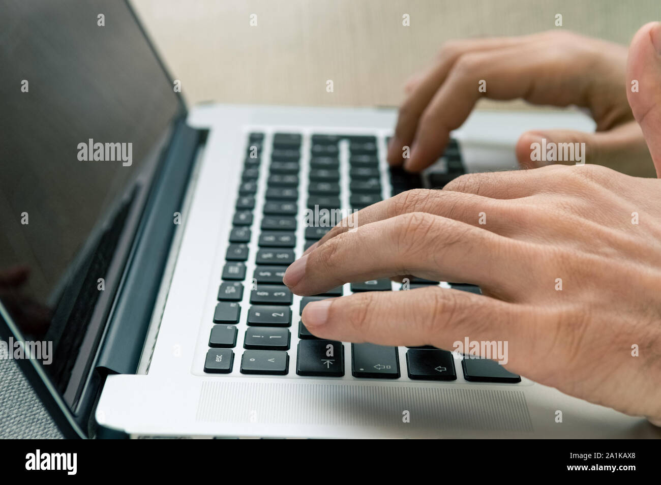Male freelancer using laptop while sitting on a comfortable couch at home. Freelancing concept. Stock Photo