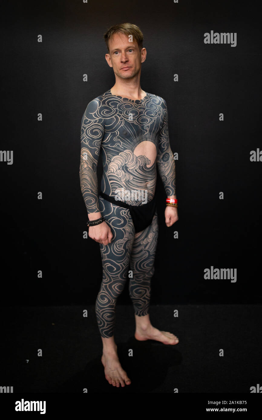 A man shows off his bodysuit during the International tattoo convention at  Tobacco Dock in east London Stock Photo - Alamy