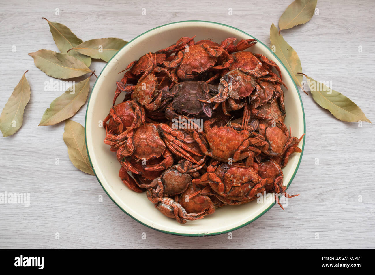 blue crabs cooked in a plate on a wooden table and bay leaves Stock Photo
