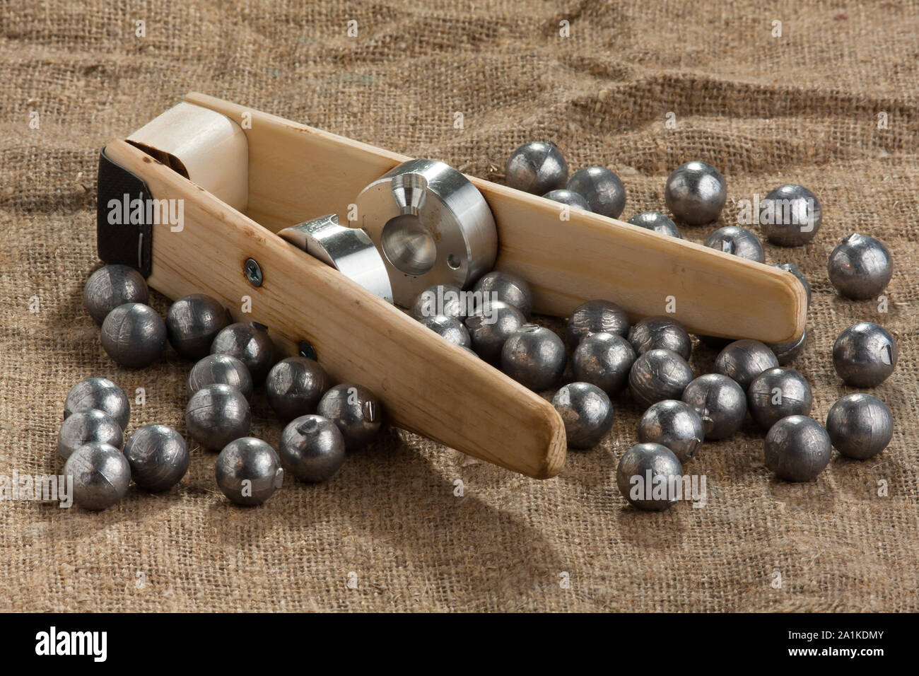 homemade bullet mold and ball-shaped bullets on burlap background Stock Photo