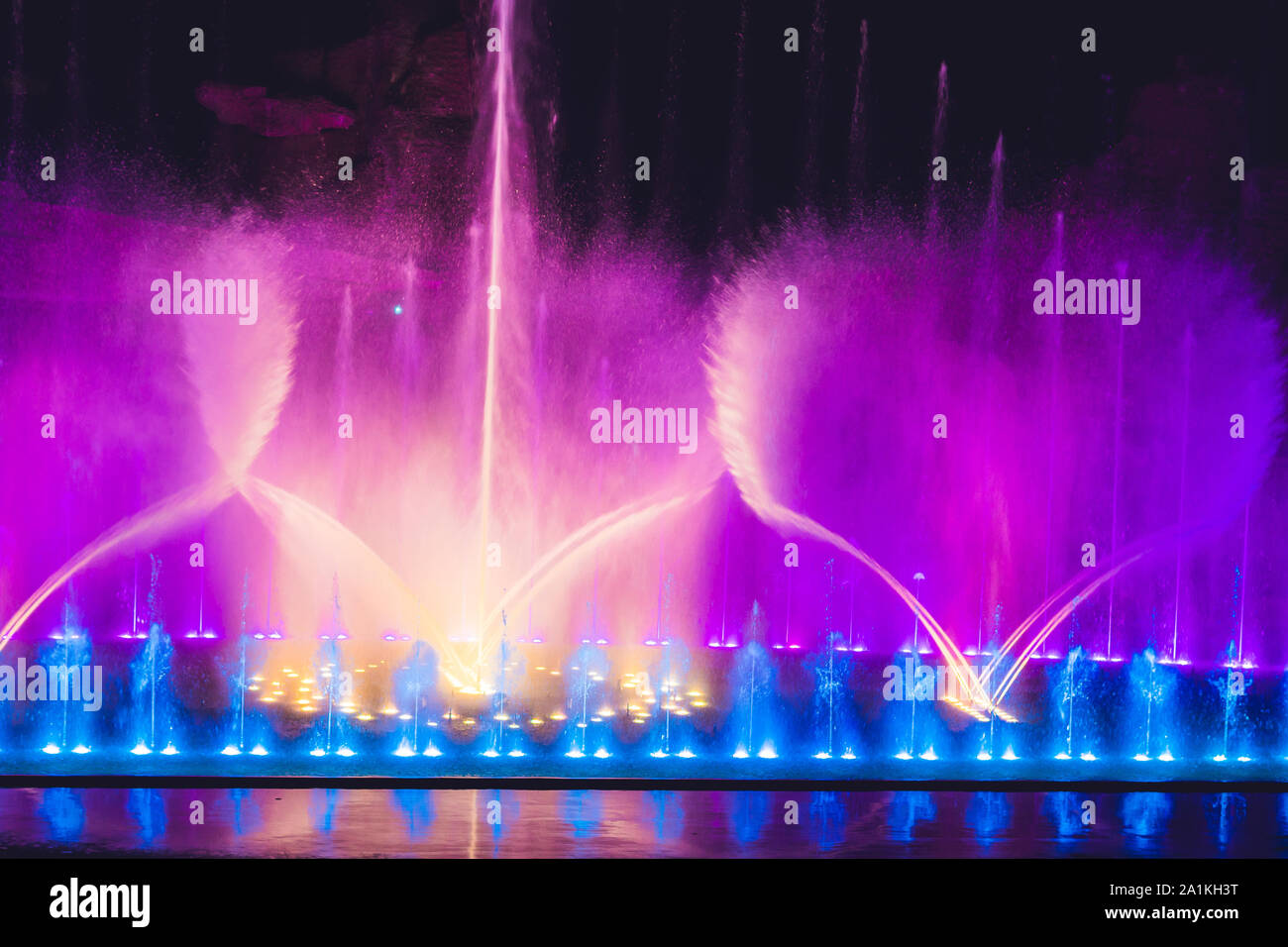 Multicolored dancing water jet fountain in the dark Stock Photo Alamy