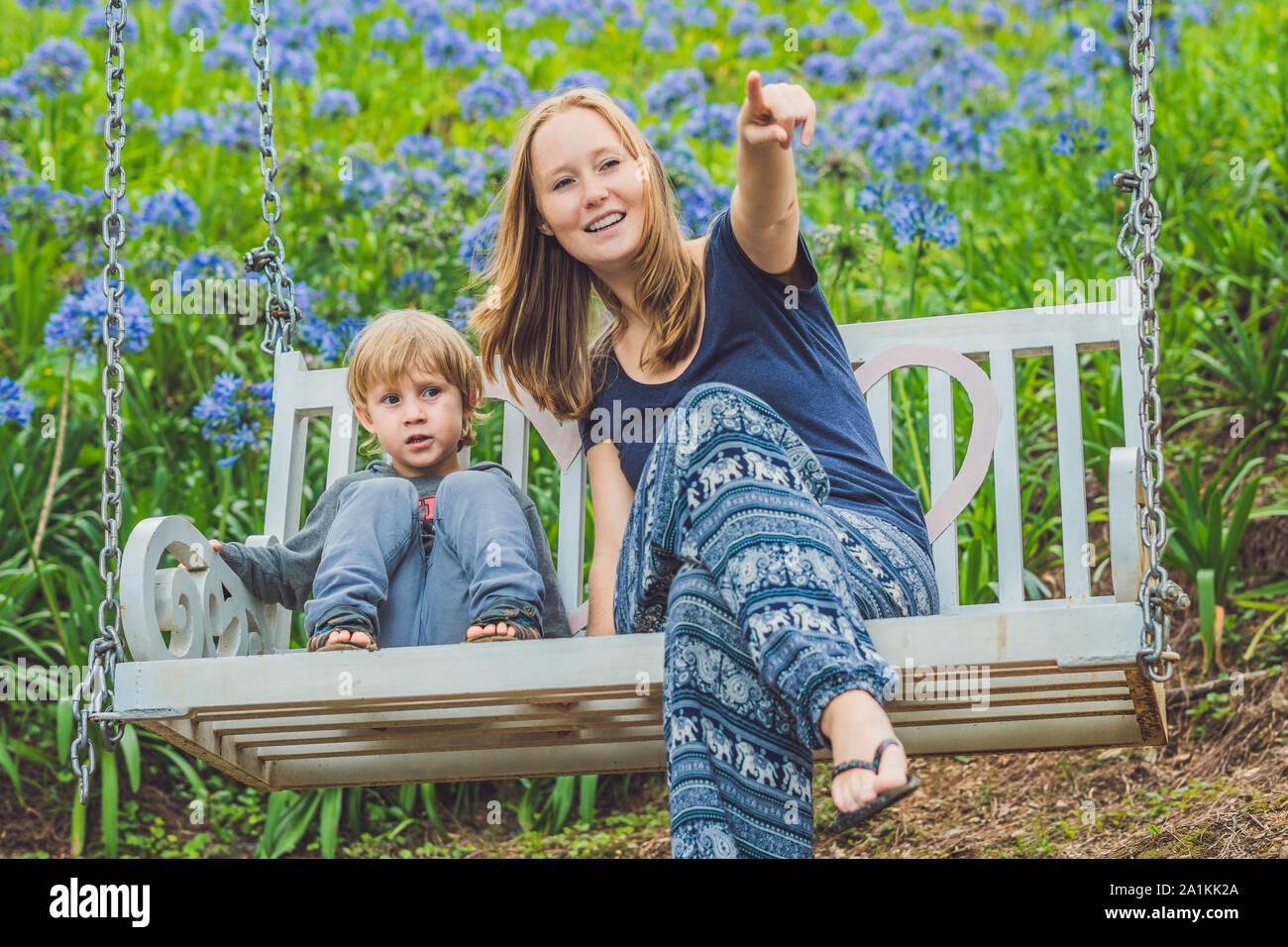 happy mother pushing laughing son on swing in a park Stock Photo - Alamy