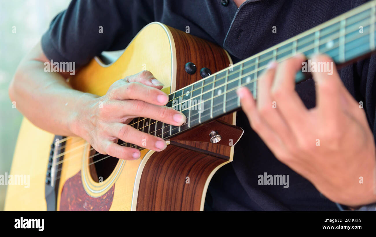 Guitarist playing the Harmonic tapping technic with acoustic guitar