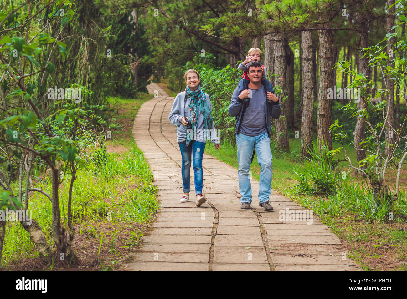 Family, mother, father and son, walking the park path Stock Photo