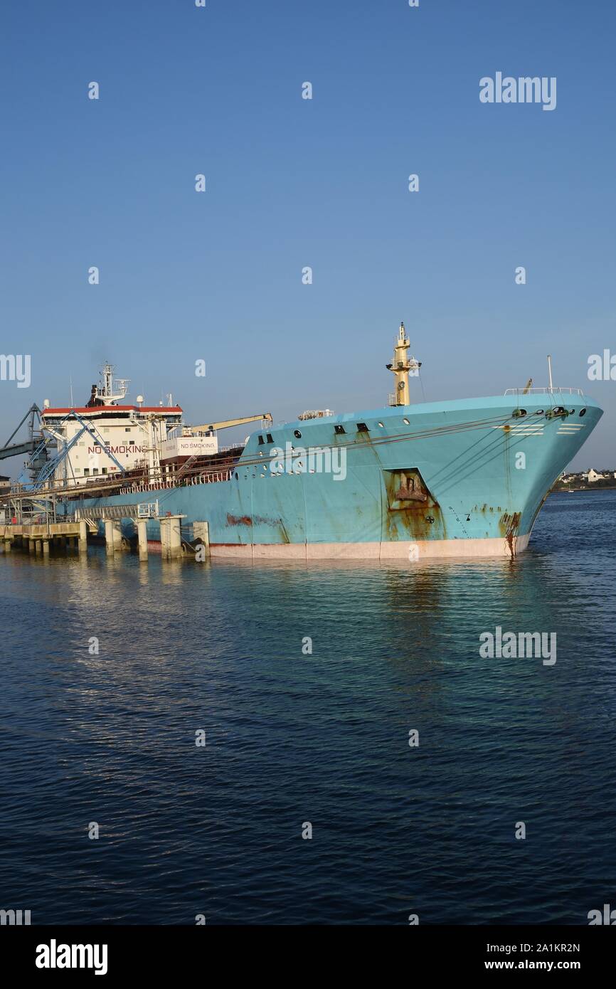 Products Tanker discharging at the Oil Terminal of lorient, France, with blue hull on sunny day. Verticale view. Stock Photo