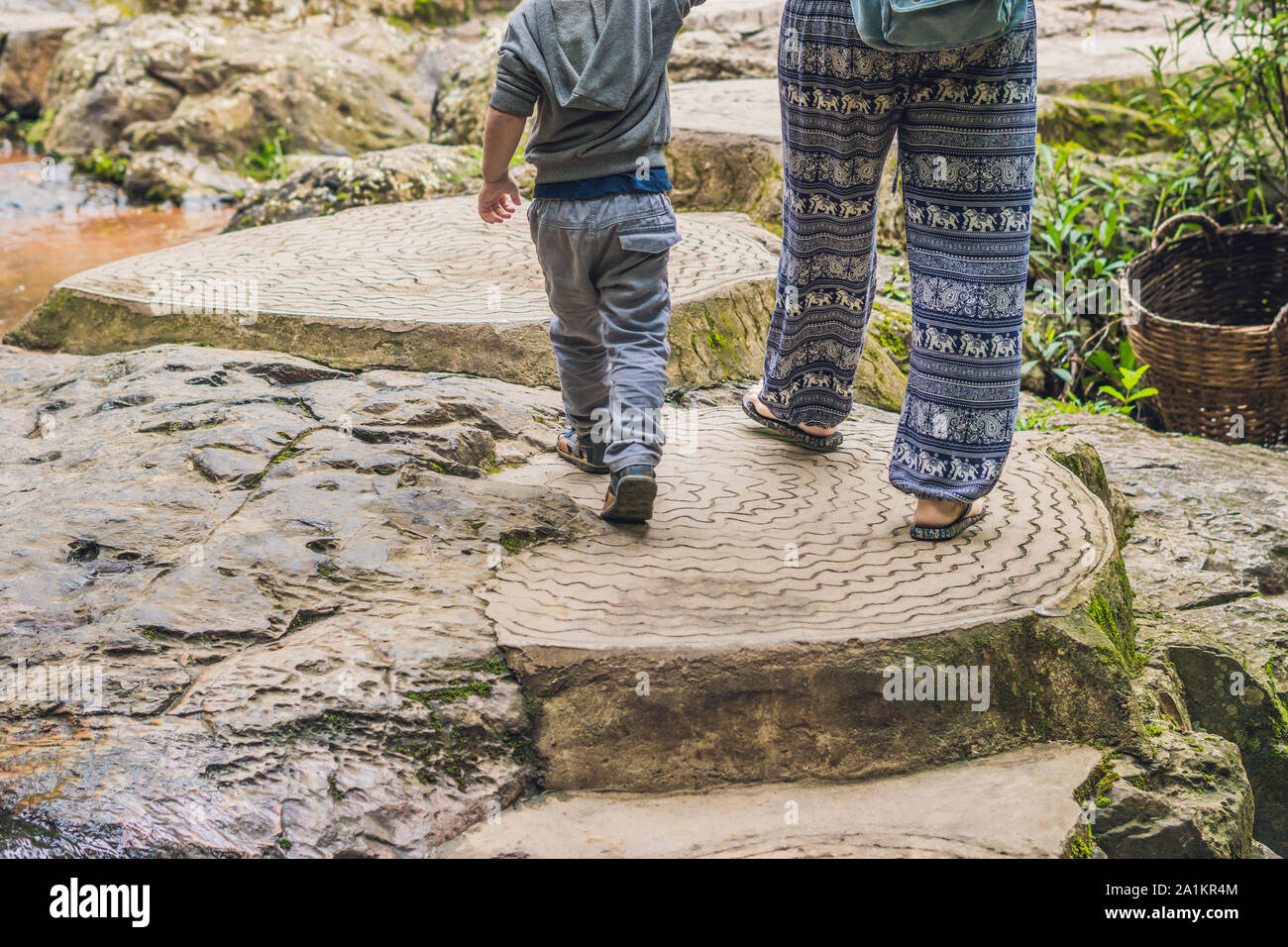 Mother and son in the background of beautiful cascading Datanla waterfall In the mountain town Dalat, Vietnam Stock Photo