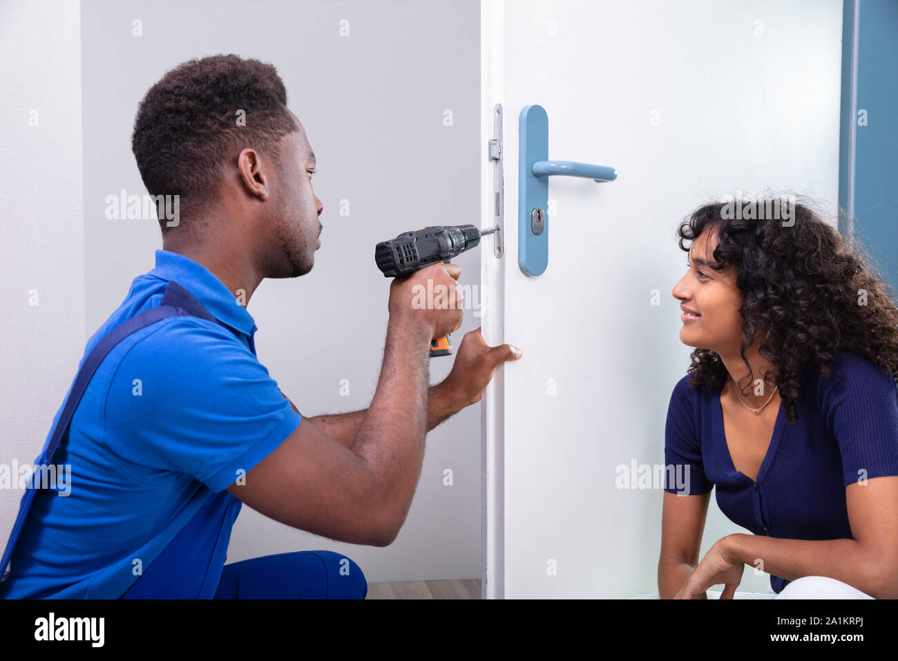 Technician Fixing The Door Lock At Clients Home Stock Photo