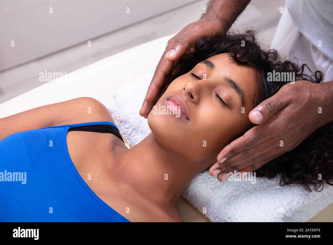 Close-up Of Therapist's Hand Performing Reiki Treatment On Young Woman In Spa Stock Photo