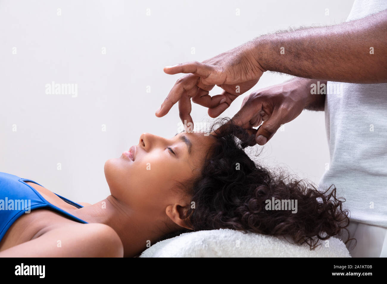 Close-up Of Therapist's Hand Performing Reiki Treatment On Young Woman In Spa Stock Photo