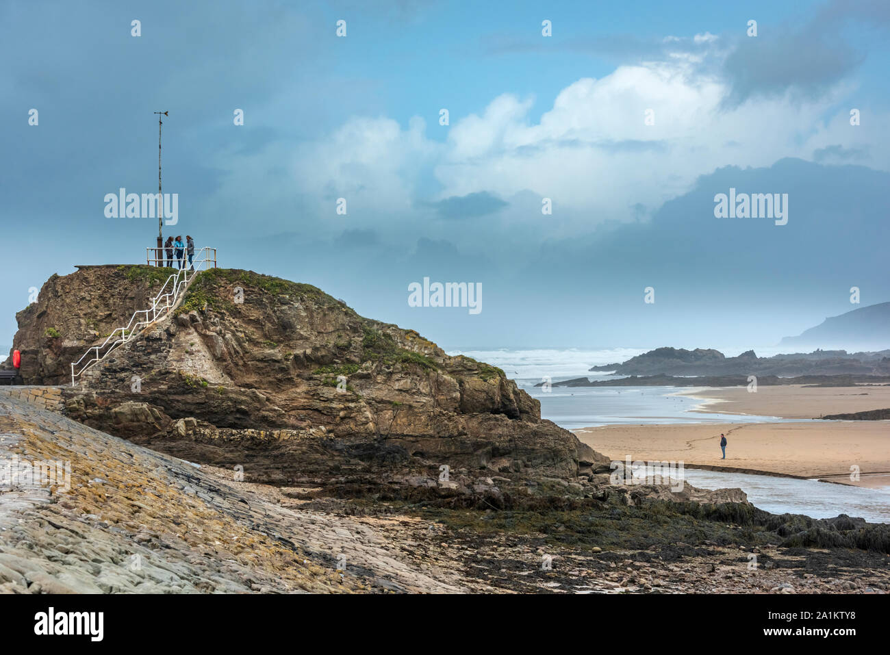 Bude, North Cornwall, England. Friday 27th September 2019. UK Weather. After a night of torrential rain and gale force winds, the stormy weather continues as a man enjoys a walk on windswept Summerleaze Beach and three friends climb the steps on the breakwater in  Bude North Cornwall. Terry Mathews/Alamy Live News. Stock Photo