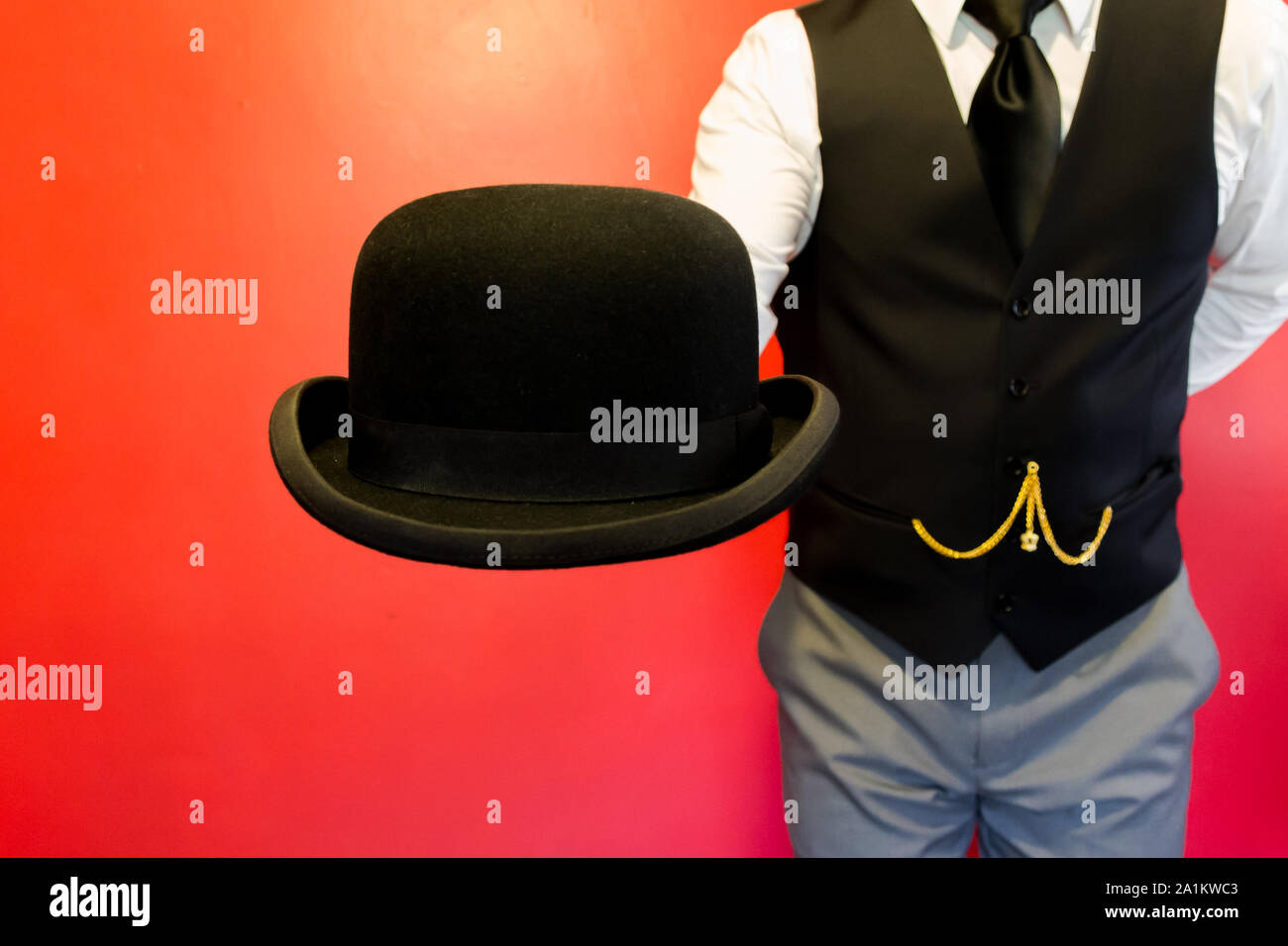 Butler Presenting a Bowler Hat. Concept of Service Industry and Professional Hospitality and Courtesy. Stock Photo