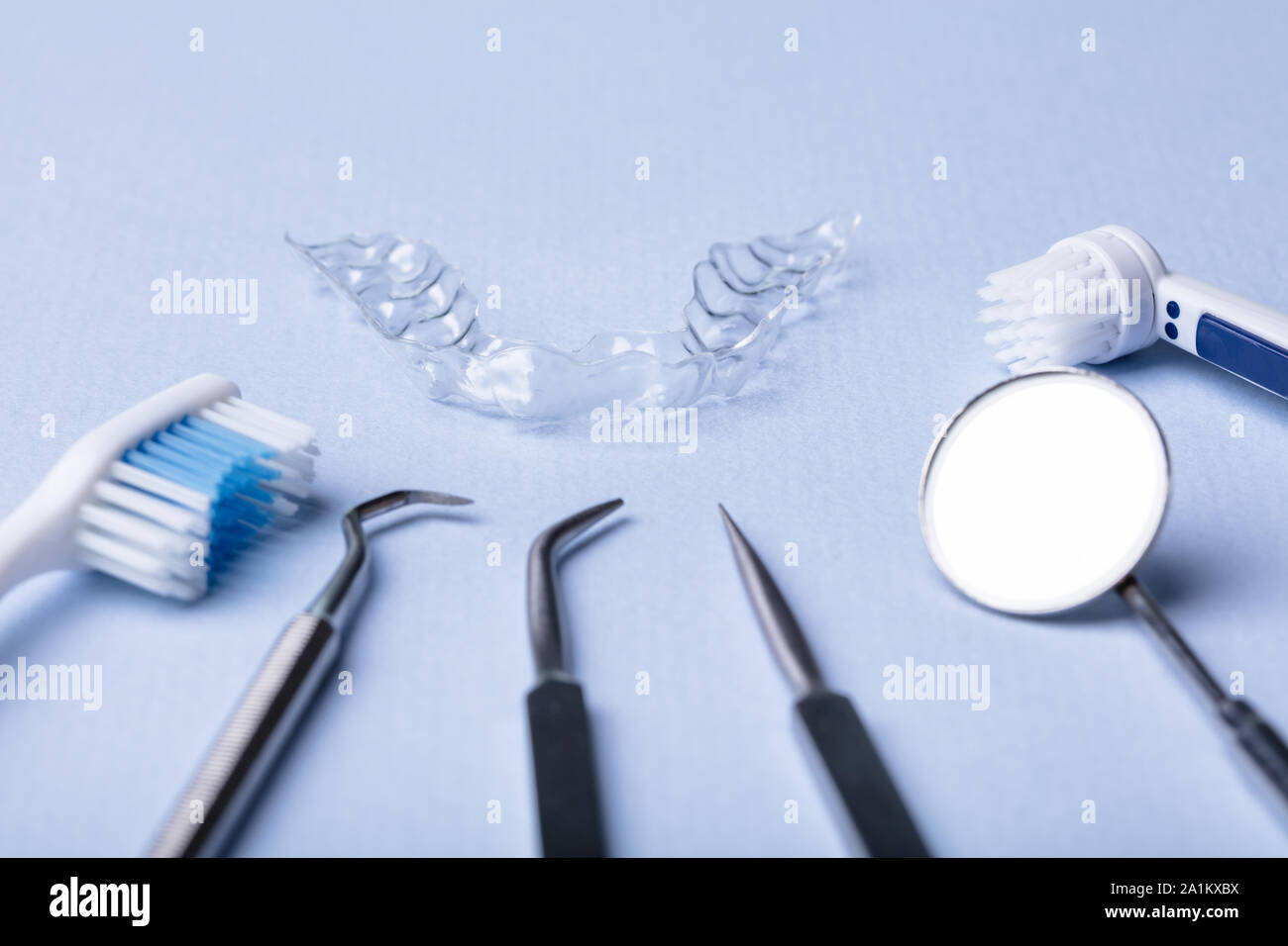Dental Instruments And Clear Aligner On Color Background Stock Photo