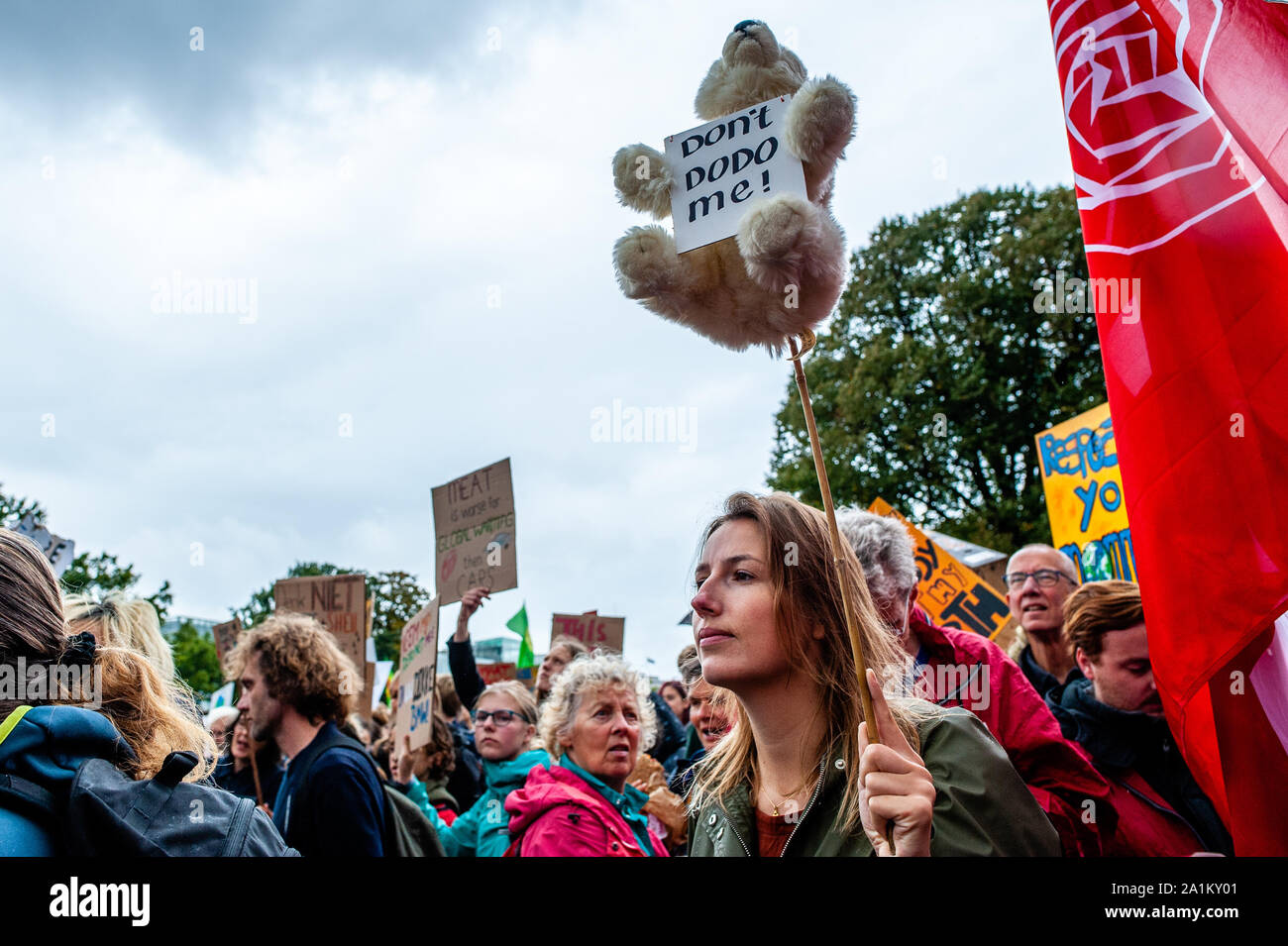 A woman holding a bear during the demonstration.Large coalition of organizations in The Netherlands organized the climate strike, and it is part of the largest international climate mobilisation in history. Building on the successful youth strikes that started almost a year ago, thousands of people strike together for the first time to demand a liveable and just world, now and for the future. Stock Photo