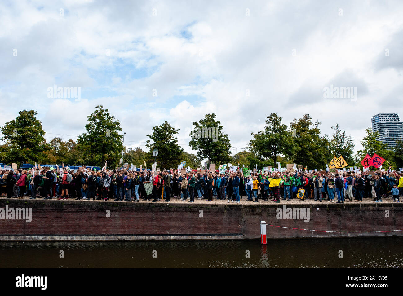 Thousands of people walking next to a canal during the demonstration.Large coalition of organizations in The Netherlands organized the climate strike, and it is part of the largest international climate mobilisation in history. Building on the successful youth strikes that started almost a year ago, thousands of people strike together for the first time to demand a liveable and just world, now and for the future. Stock Photo