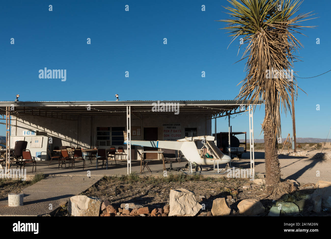 Not only is that a helicopter, or the remains of one, under the overhang, but also the building is the headquarters of the local American Legion, post 653, in sparsely settled Terlingua in Brewster County, Texas, north of Big Bend National Park Stock Photo