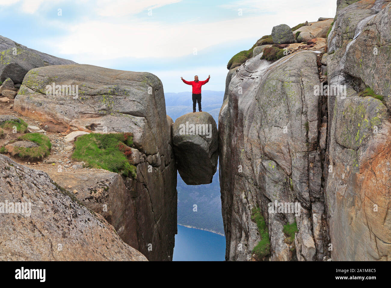 Hiker standing on the top of Kjerag Rock over the Lysefjord in Norway Stock Photo