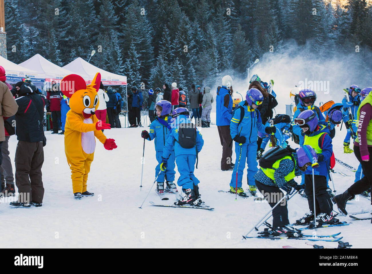 Bansko, Bulgaria - December, 12, 2015: Many young skiers preparing to ski in Bansko, Bulgaria and Mouse in Costume Stock Photo