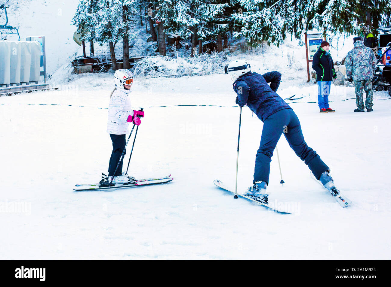 Bansko, Bulgaria - December 12, 2015: The girl learning to ski with instructor on the slope in Bansko, Bulgaria Stock Photo