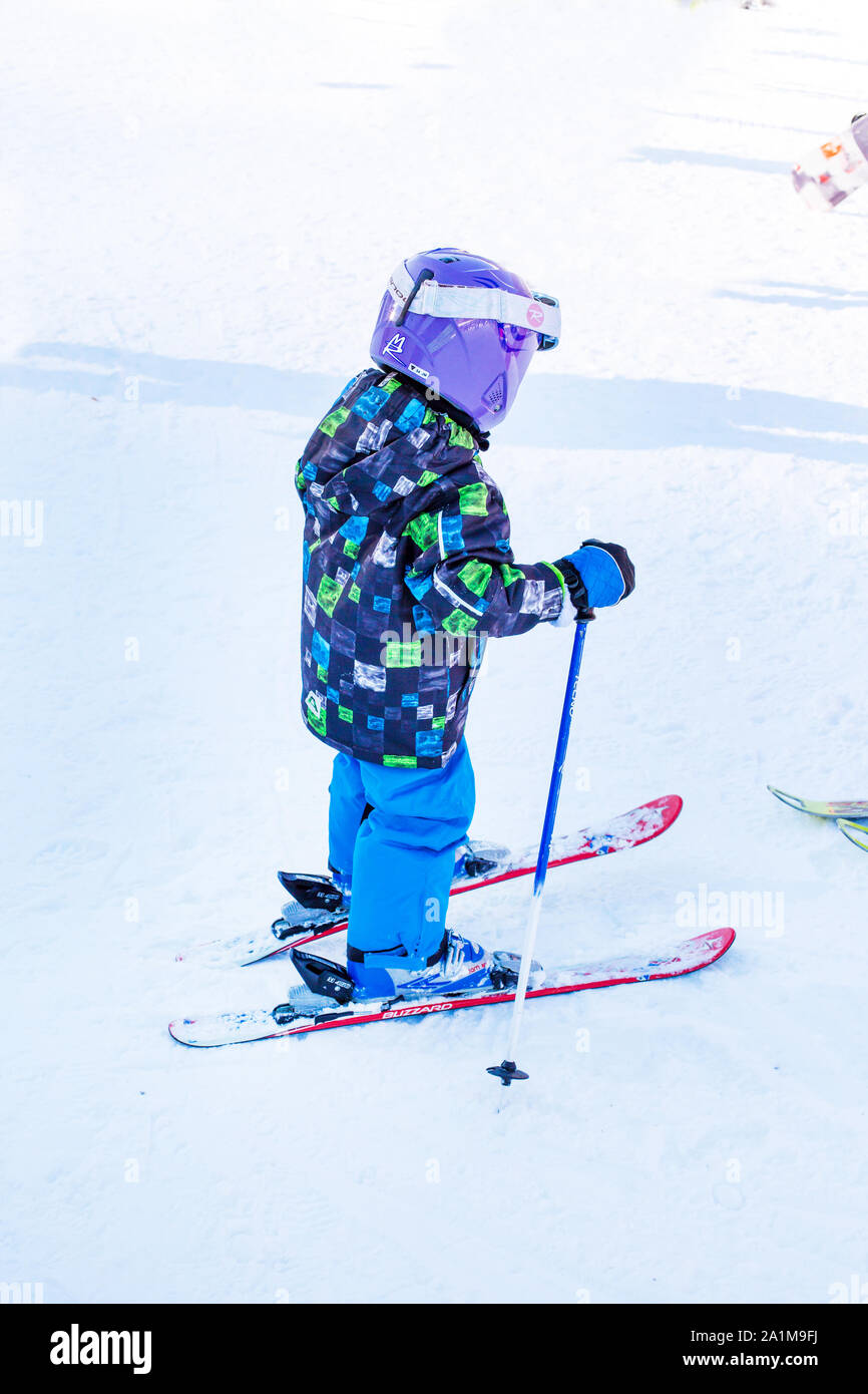 Bansko, Bulgaria - December, 12, 2015: The small child learning to ski on the slope in Bansko, Bulgaria Stock Photo