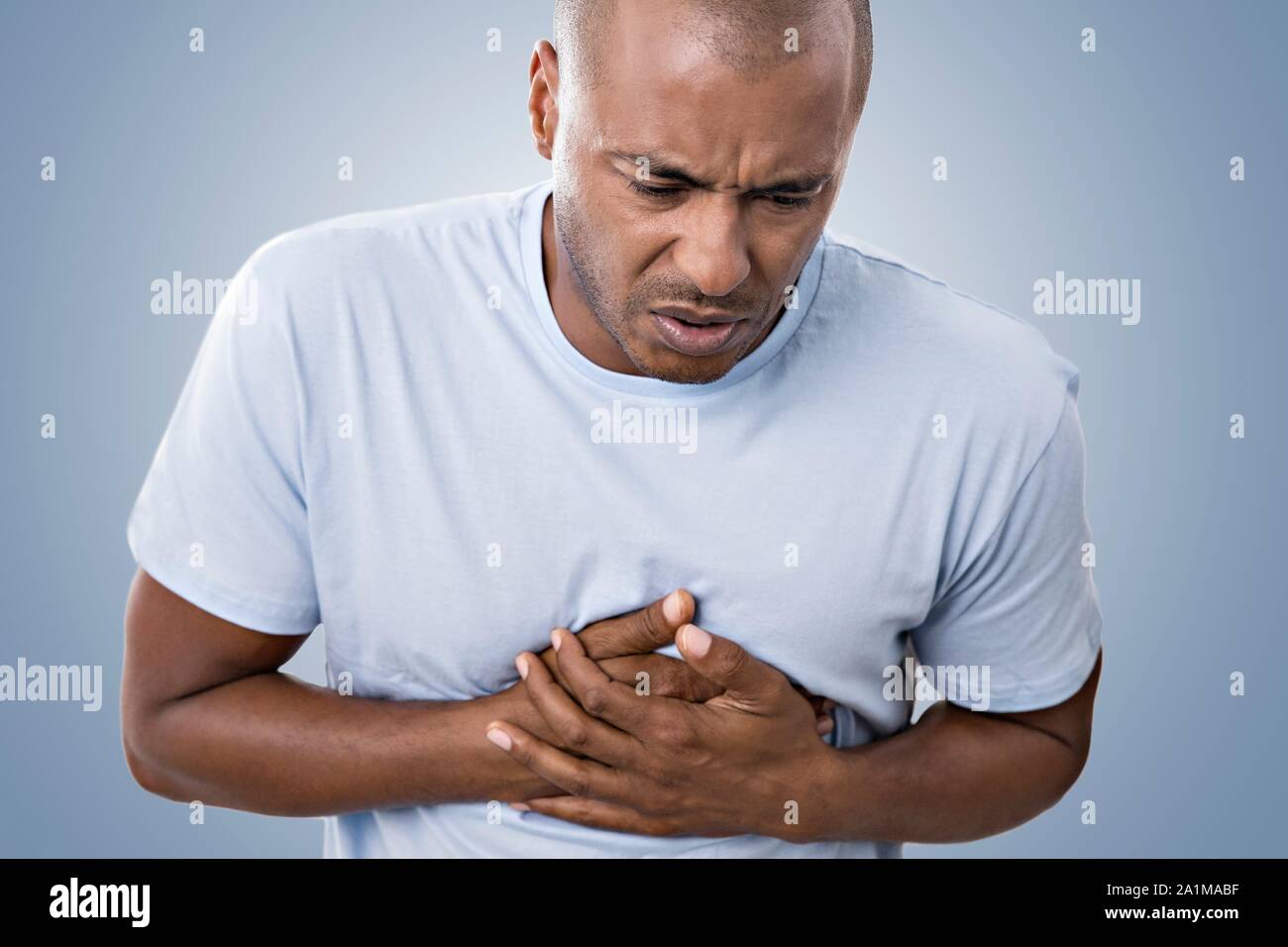 Man clutching his chest in pain. Stock Photo