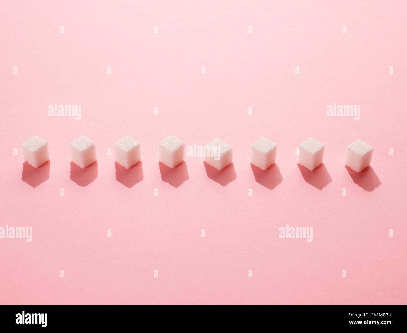 Sugar cubes on pink background Stock Photo - Alamy