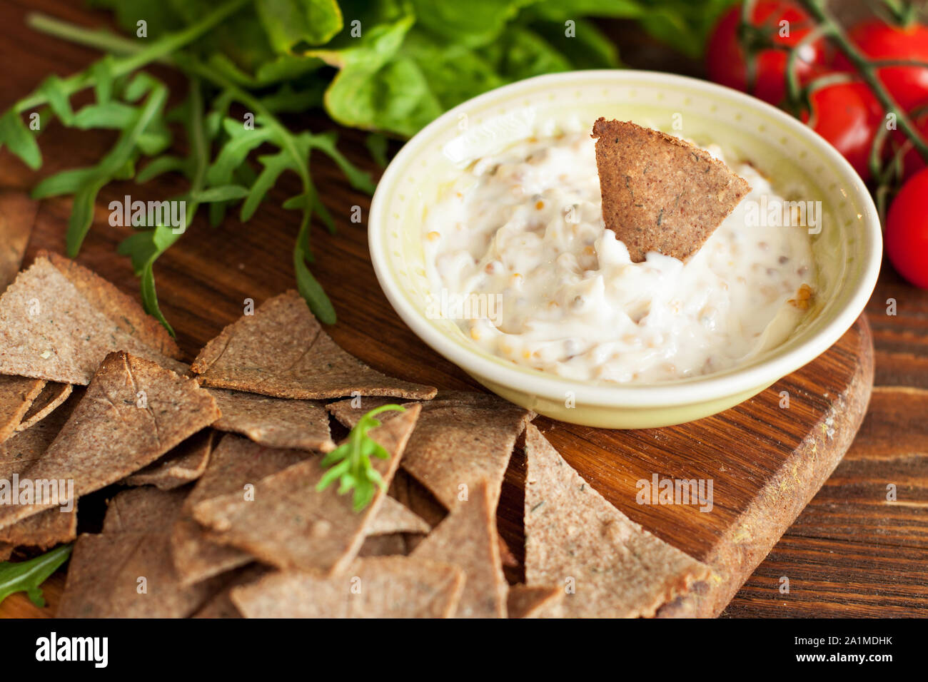 Gluten Free Dipping Chips Served With Mustard Sauce Arugula And Cherry Tomatoes On Wooden Cutting Board Stock Photo Alamy