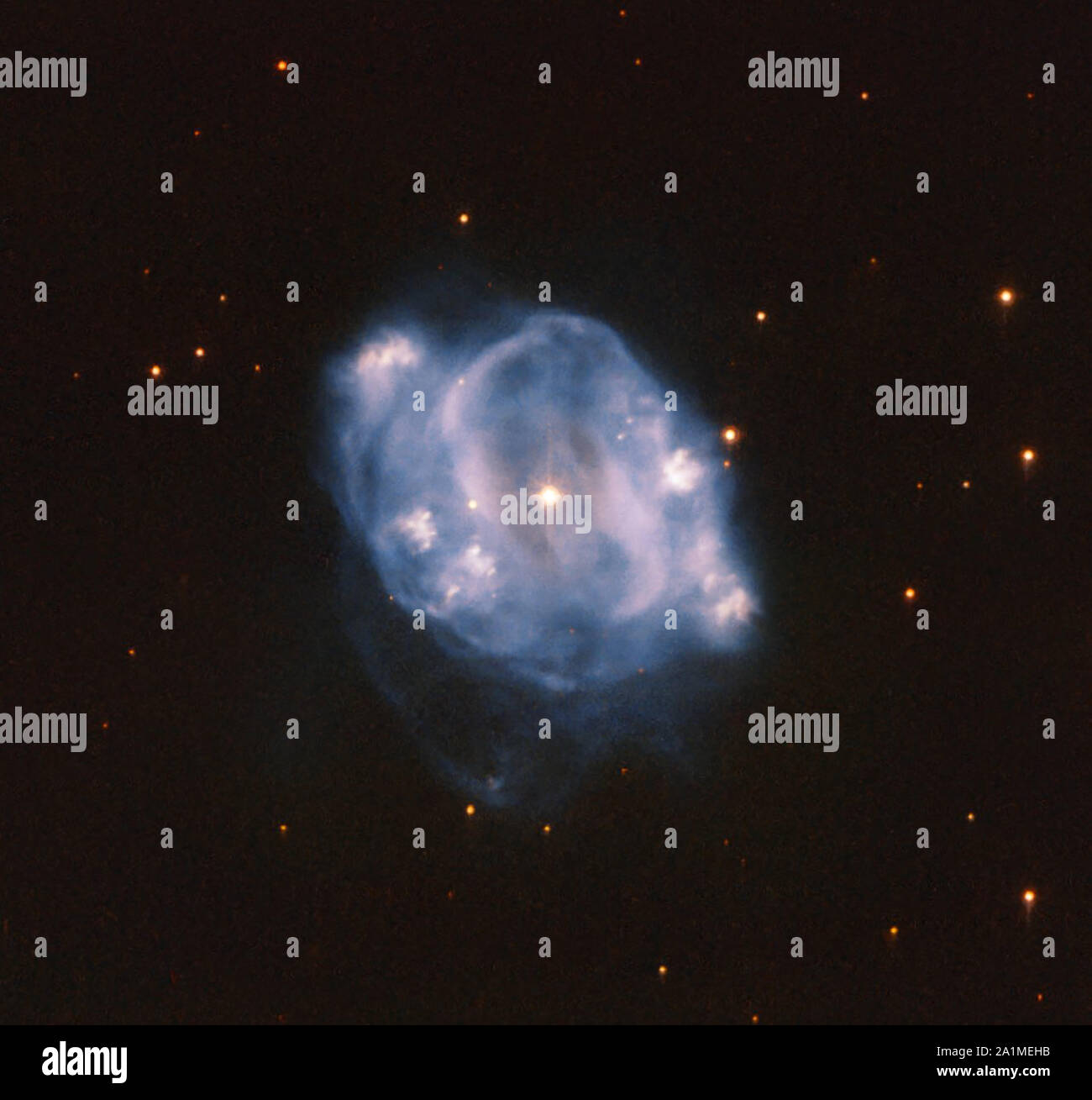 This image from the NASA/ESA Hubble Space Telescope shows NGC 5307, a planetary nebula that lies about 10,000 light-years from Earth. It can be seen in the constellation Centaurus (the Centaur), which can be seen primarily in the southern hemisphere. A planetary nebula is the final stage of a Sun-like star. As such, planetary nebulas allow us a glimpse into the future of our own solar system. A star like our Sun will, at the end of its life, transform into a red giant. Stars are sustained by the nuclear fusion that occurs in their core, which creates energy. The nuclear fusion processes consta Stock Photo