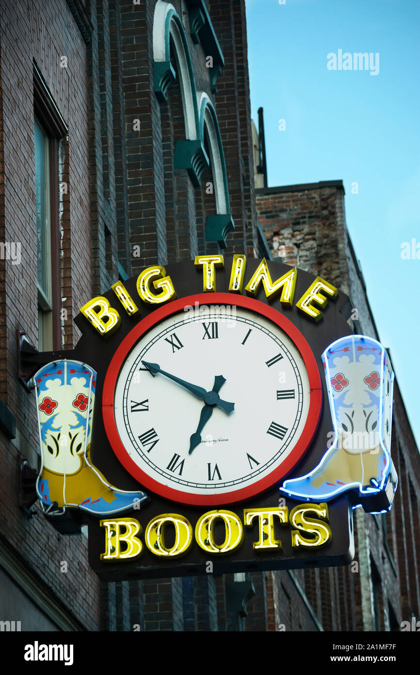 Cowboy Boot Clock A sign with a clock and cowboy boots hangs over the entrance to a ...