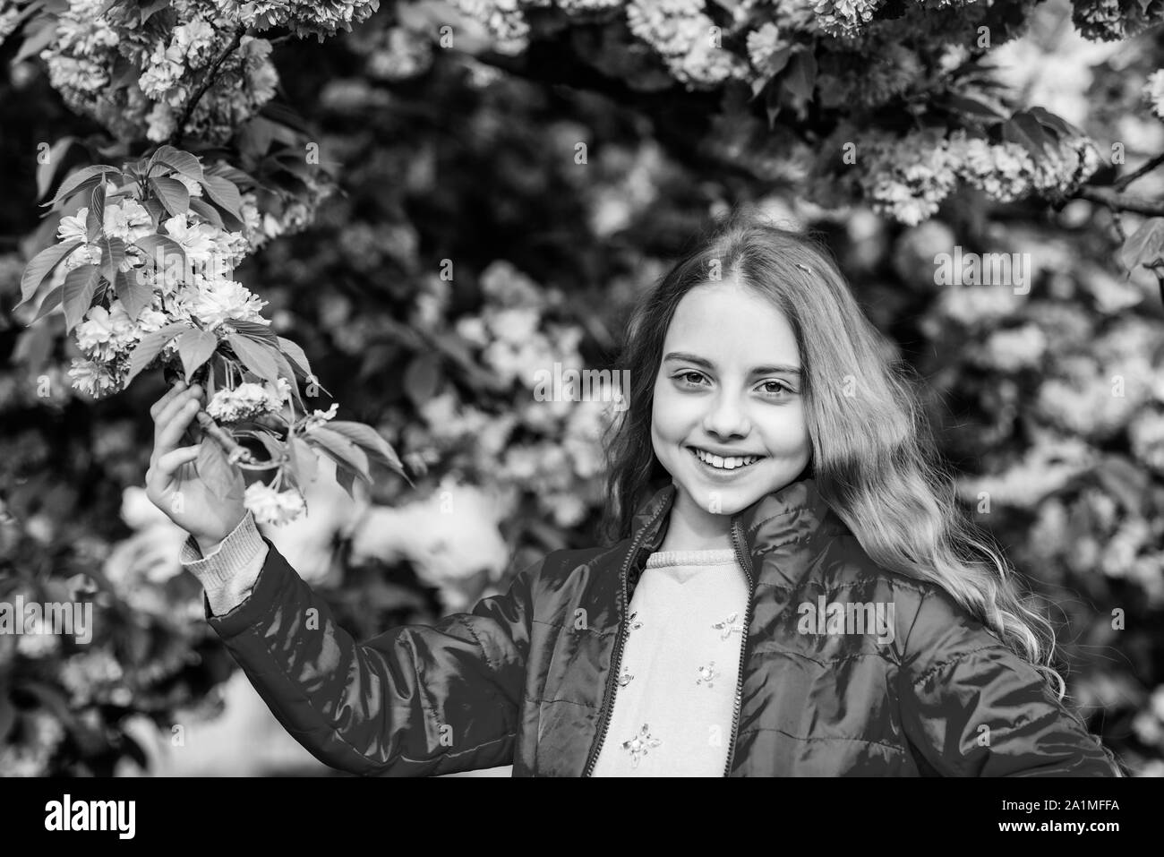 Park and garden. Girl little child in spring flower bloom. Enjoy smell
