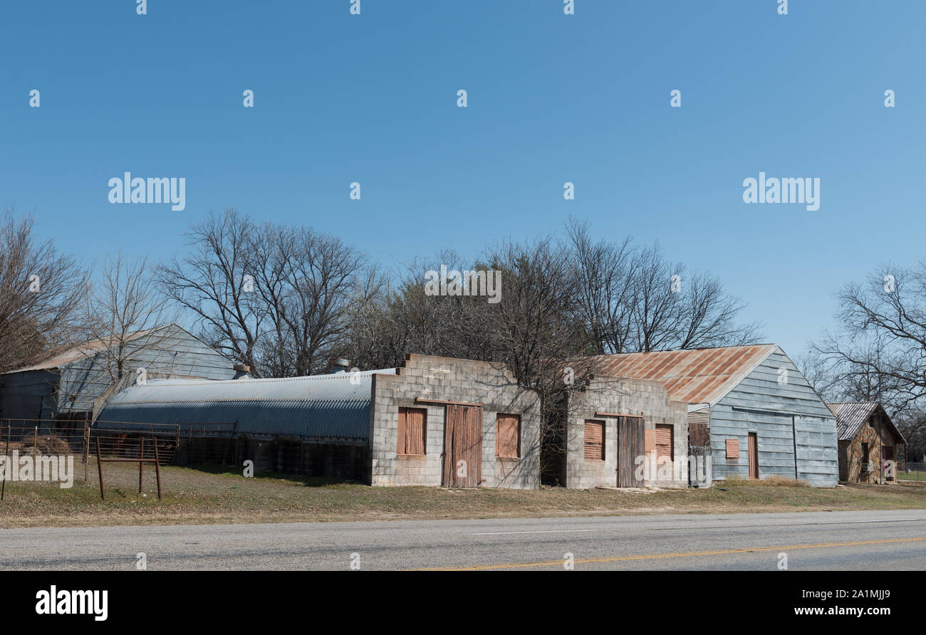 Old roadside buildings, including a partial quonset structure, in