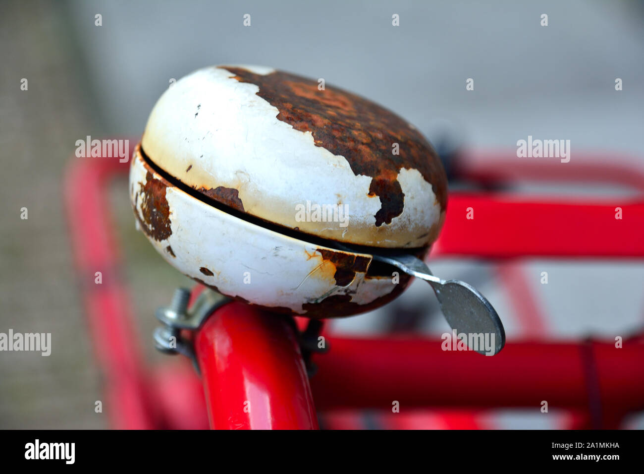 A closeup photo of a rusty and well worn old bicycle bell on a red bike frame Stock Photo