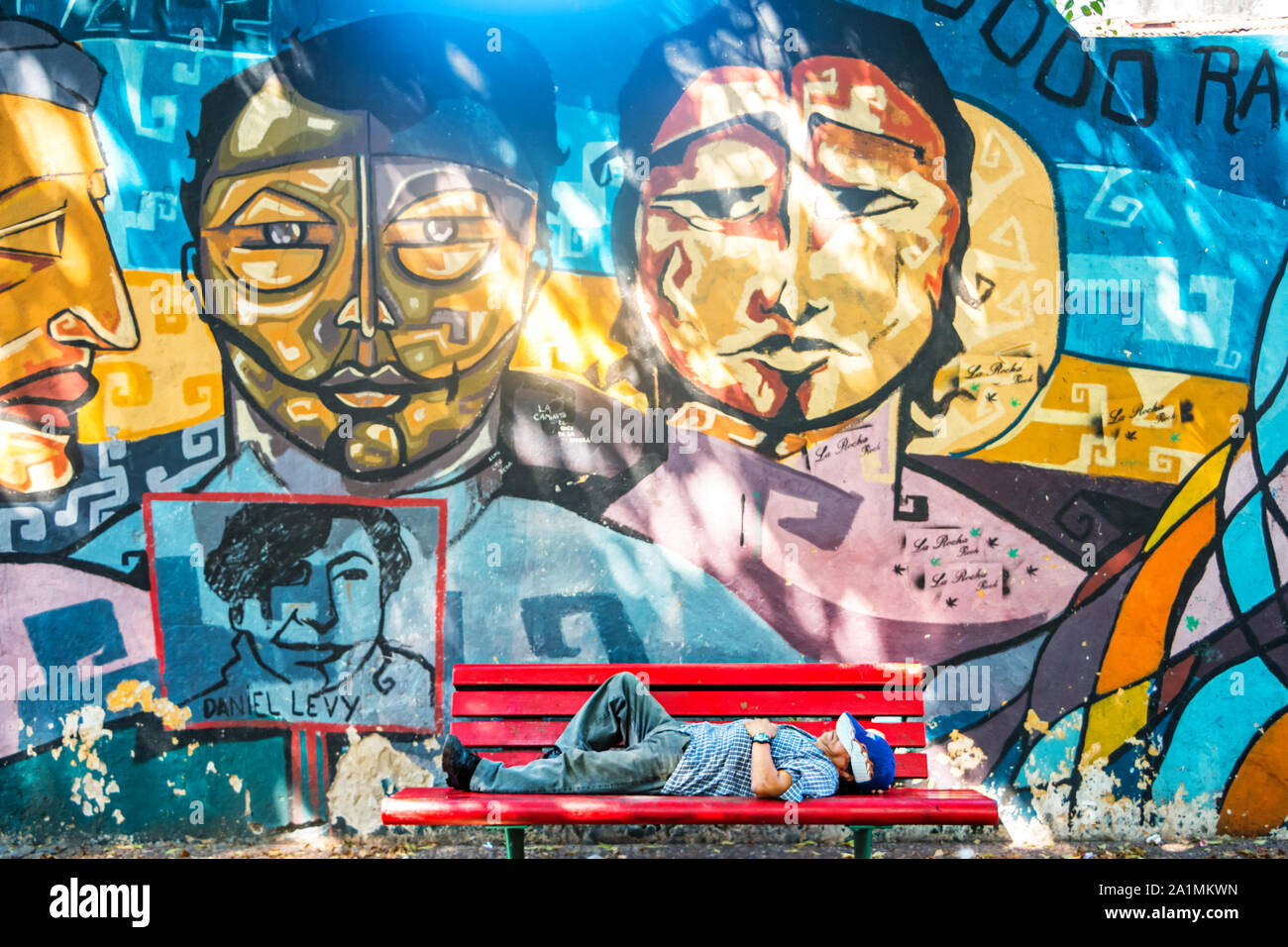 Man sleeps on a bench in Buenos Aires, Argentina on a sunny day. Stock Photo