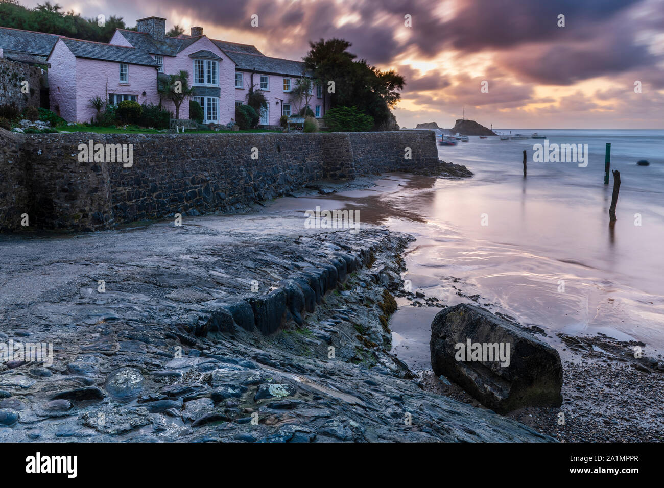 Bude, North Cornwall, England. Friday 27th September 2019. UK Weather. After a stormy day, the sun sets over the breakwater, as heavy showers and strong winds continue to batter Bude in North Cornwall. Terry Mathews/Alamy Live News. Stock Photo