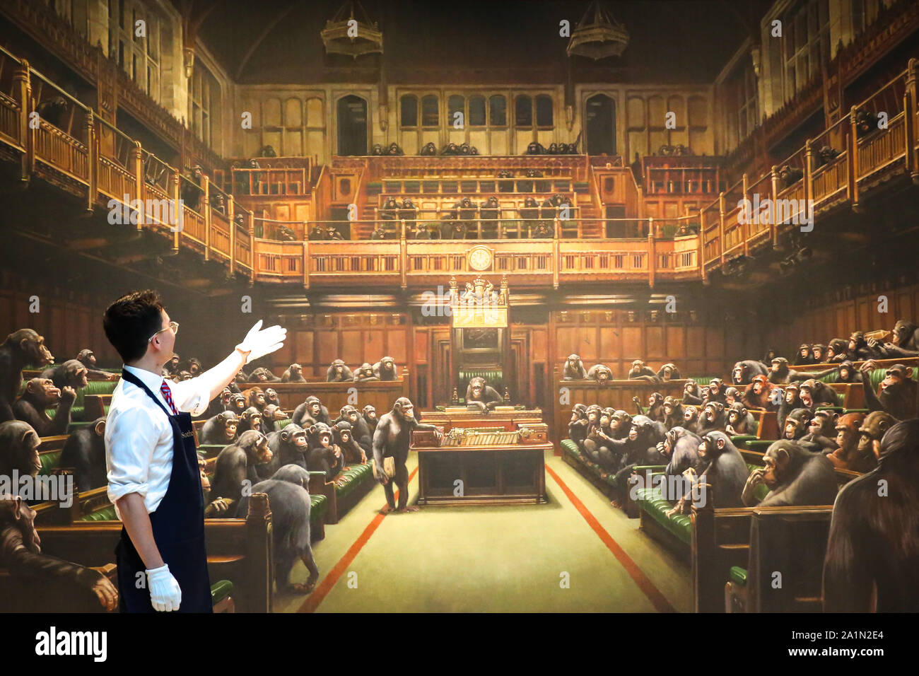 A Sotheby's technician is seen in front of Banksy painting 'Dystopian, View of The House of Commons at London Sotheby's. The painting will be auctioned next month and is estimated at GBP1.5 to GBP2 million. Stock Photo