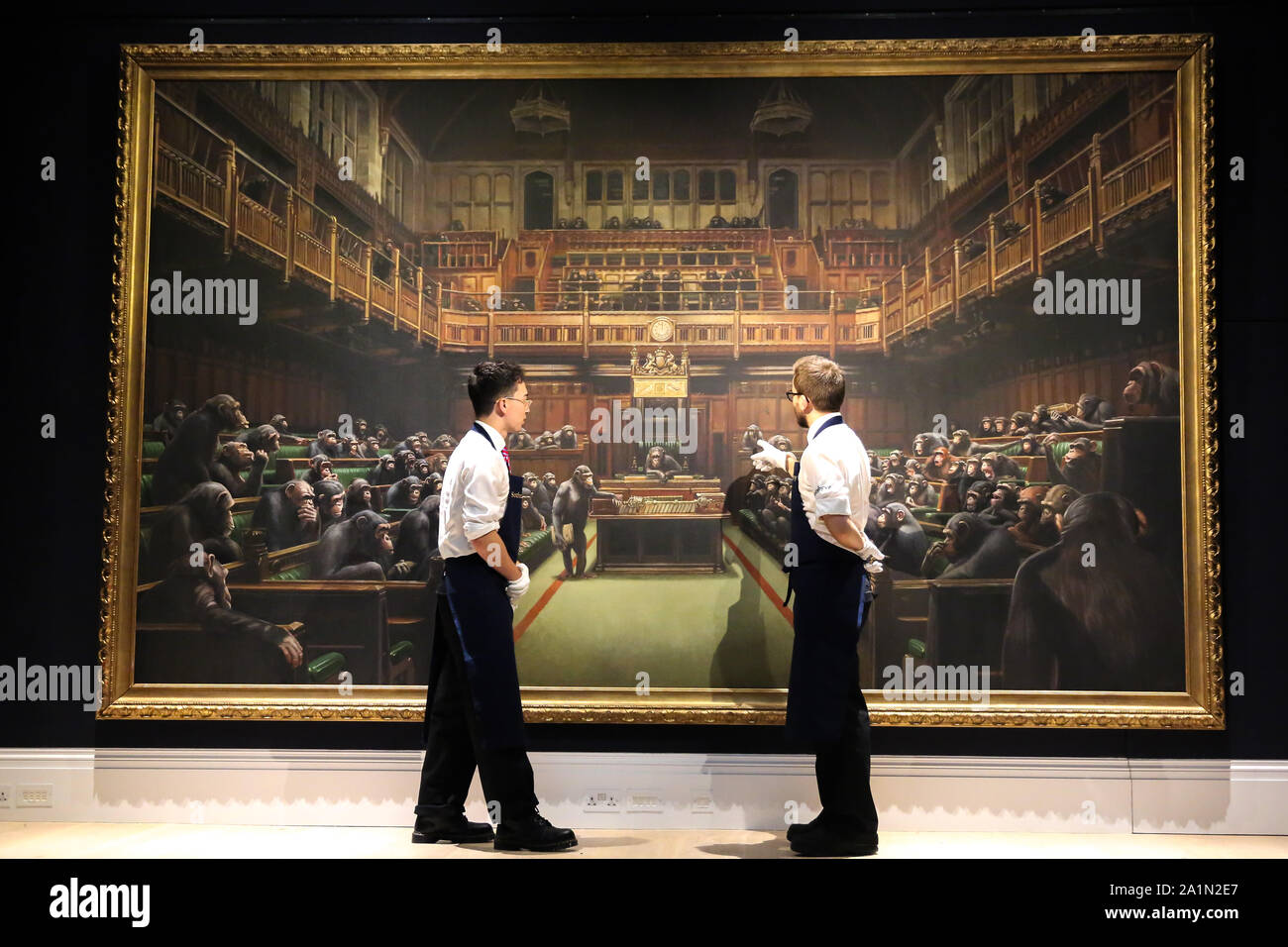 Sotheby’s technicians are seen in front of Banksy painting 'Dystopian, View of The House of Commons at London Sotheby's. The painting will be auctioned next month and is estimated at GBP1.5 to GBP2 million. Stock Photo