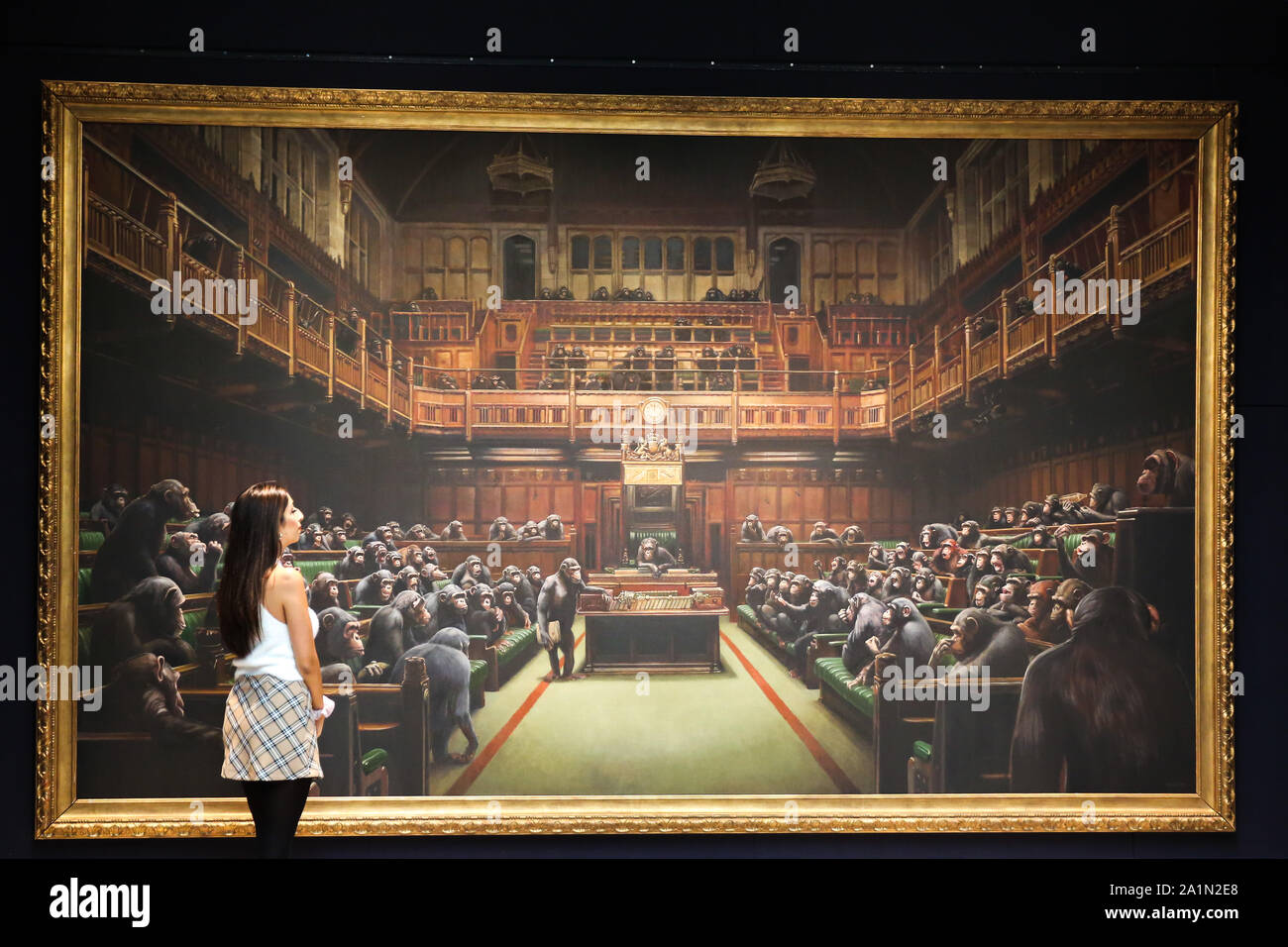 A Sotheby's staff is seen in front of Banksy painting 'Dystopian, View of The House of Commons at London Sotheby's.The painting will be auctioned next month and is estimated at GBP1.5 to GBP2 million. Stock Photo