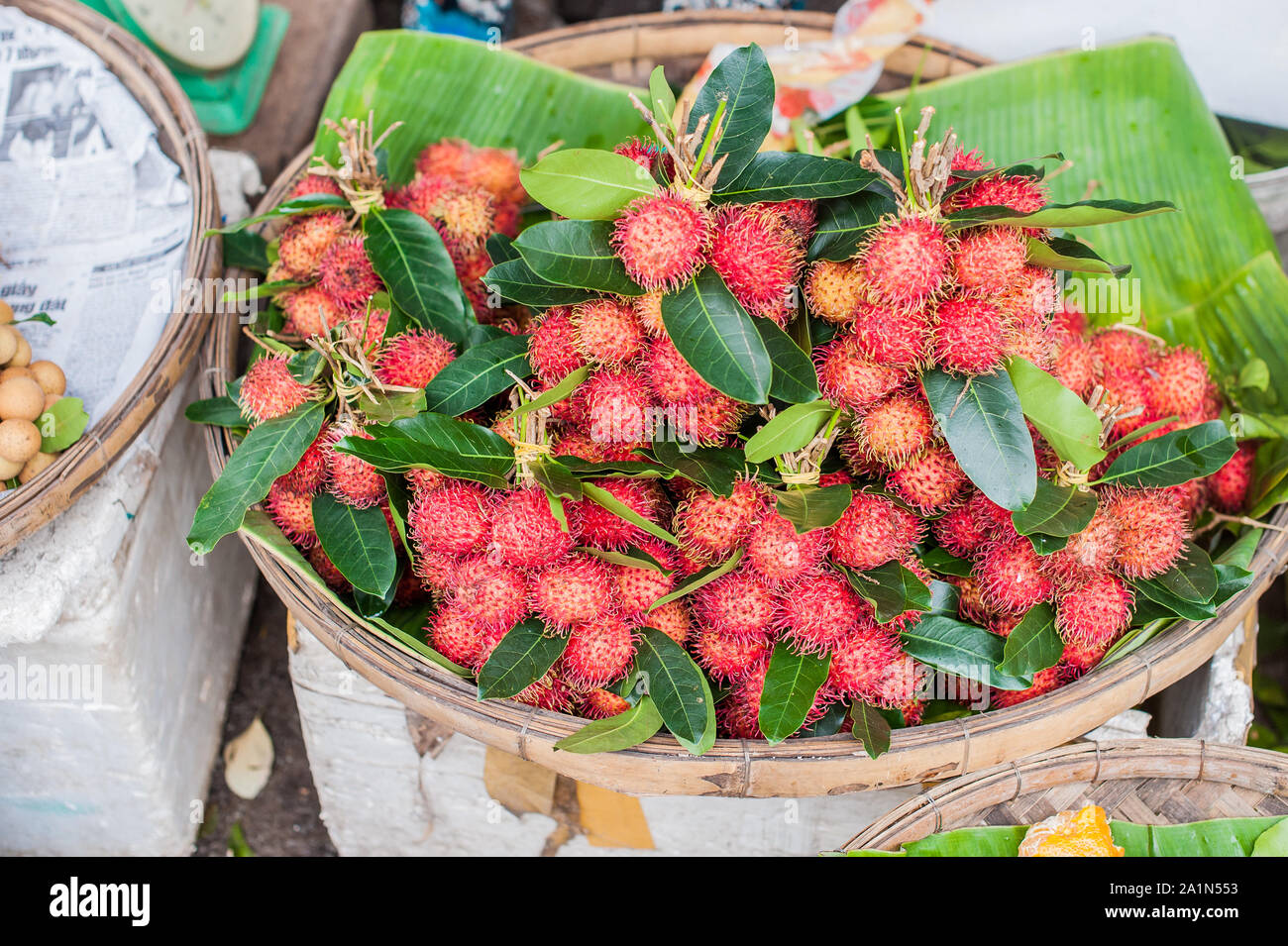 bunch of rambutan in the wicker basket on the Vietnamese market Stock Photo
