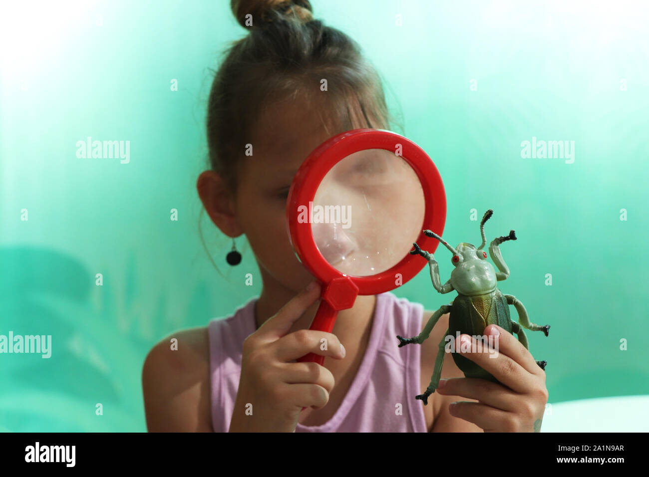 Child studying a toy buy through a magnifying glass Stock Photo