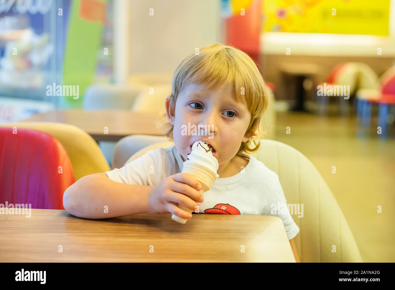 Little blond toddler child eating vanilla ice cream Stock Photo Alamy