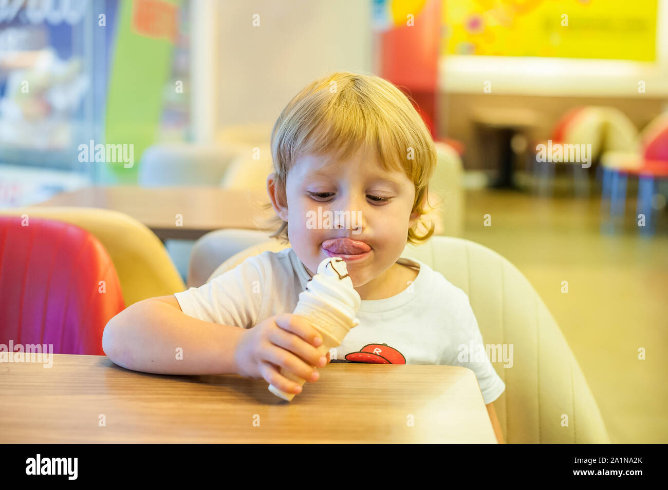 Little blond toddler child eating vanilla ice cream Stock Photo Alamy
