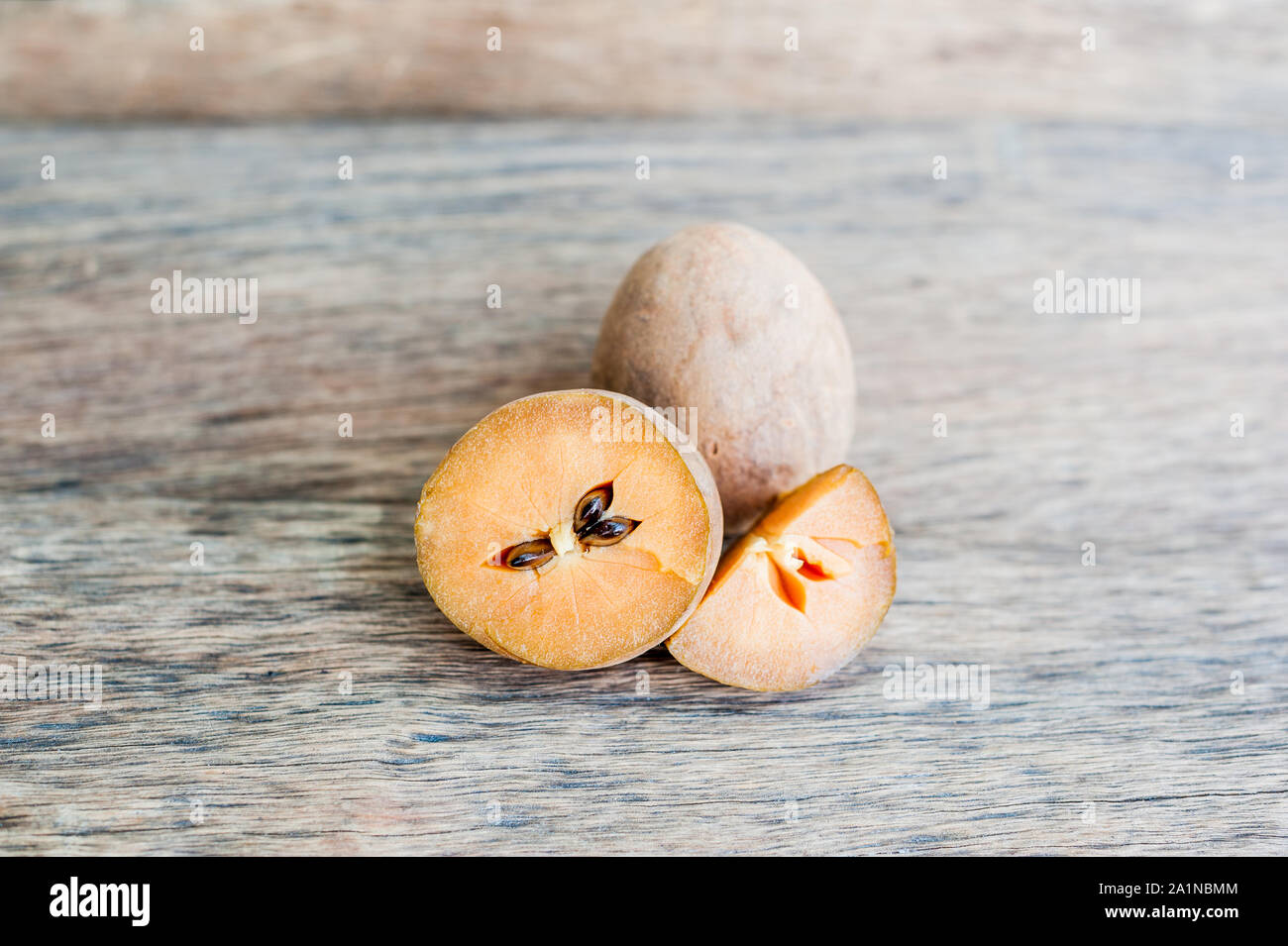 fresh sapodilla fruits on old wooden background Stock Photo