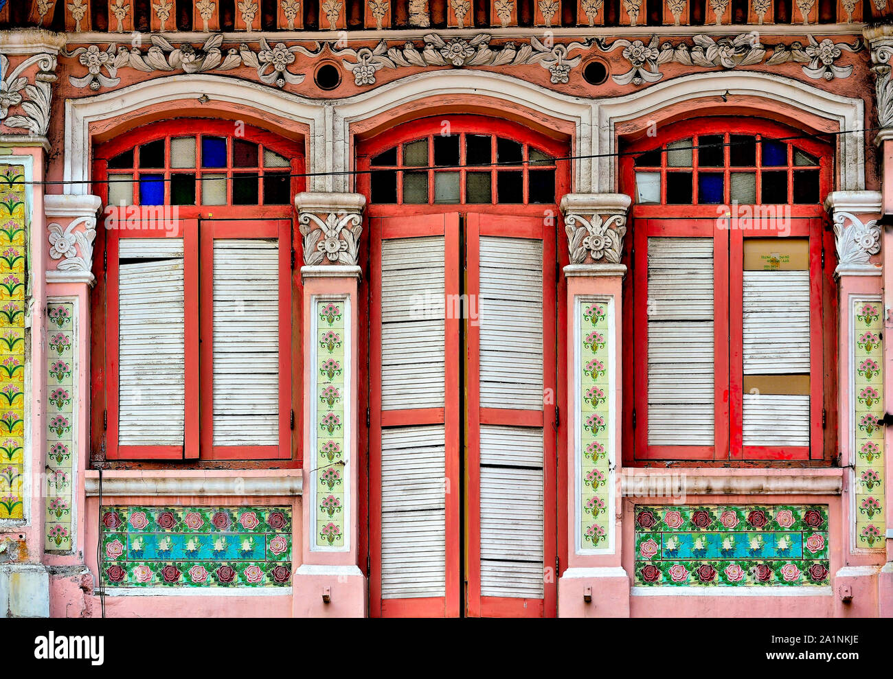 Front view of colourful heritage Singapore shop house with red and
